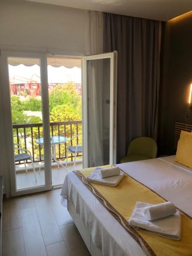 a hotel room with a bed and a balcony at Metropolitan Complex Suite 2@faliro in Piraeus
