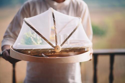 Sang Poy Cottage في Ban Kung Mai Sak: رجل يمسك ساعة في يده