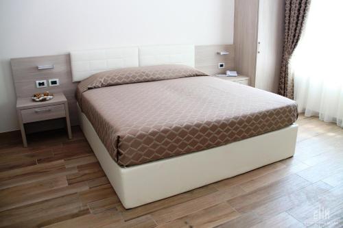 a bedroom with a bed and two night stands at Expo Hotel Milan in Parabiago