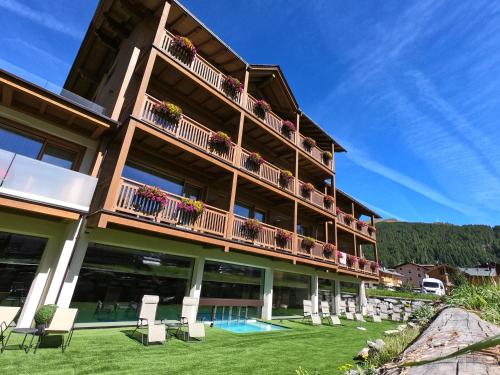 a large building with a balcony and a swimming pool at Francesin Active Hotel in Livigno