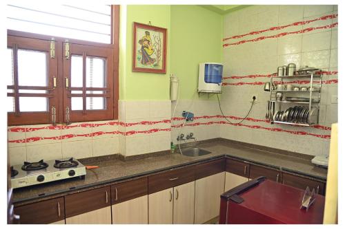 齋浦爾的住宿－SOHANAs Homestays- 2 BHK Luxury Apartment near Jaipur International Airport，厨房配有水槽和炉灶。