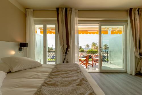a bedroom with a bed and a view of a patio at La Dolce Vita Hotel in Menton