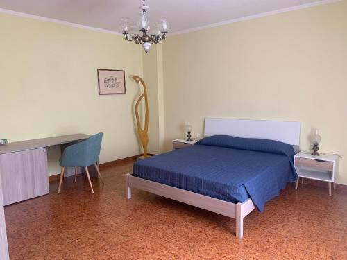 a bedroom with a bed and a desk and a chair at B&B Murichessa(Il Gelso) in Orosei