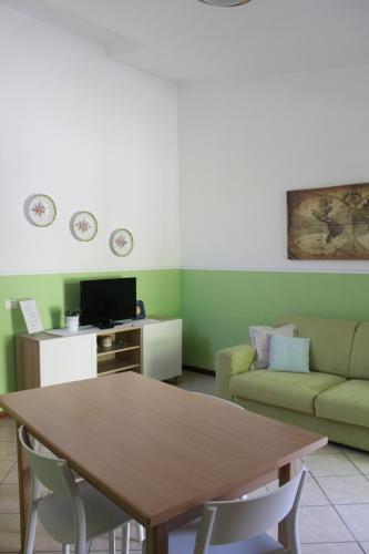uma sala de estar com uma mesa e um sofá em IL TURRIONE "app. San Rufino" em Assis
