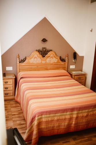 a bedroom with a large bed and two dressers at Hostal la Campana in Motril