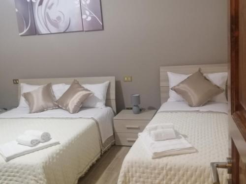 1 dormitorio con 2 camas con sábanas blancas en The opposites, en Cinisi