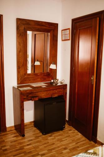 a room with a wooden desk with a mirror at Hostal la Campana in Motril