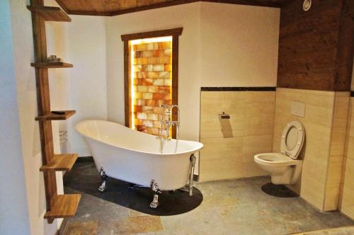 a bathroom with a white tub and a toilet at Alpengasthof Krische in Murau
