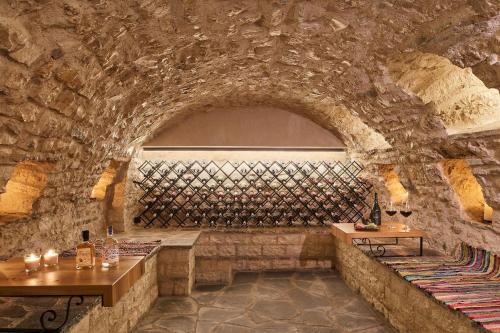 a wine cellar with two tables and a wall of wine bottles at IALNA Boutique Hotel in Ioannina