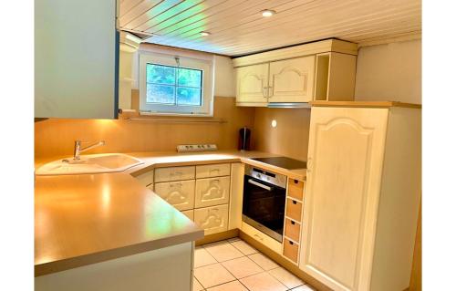 a kitchen with white cabinets and a sink at Sauerland-Relax in Schmallenberg