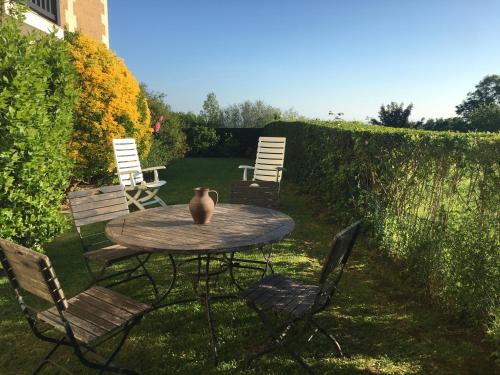 une table avec des chaises et un vase au-dessus dans l'établissement Résidence Brise du Large - Grand appartement 6 personnes magnifique vue mer, à Villers-sur-Mer