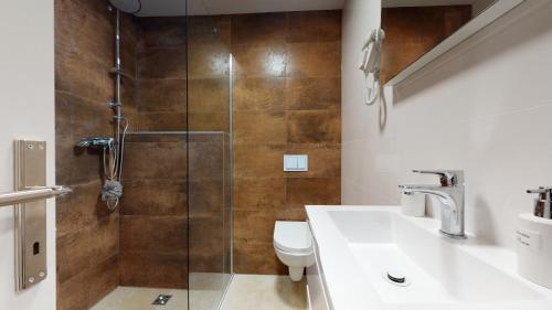 a bathroom with a shower with a toilet and a sink at WooW Apartments in Velika Gorica