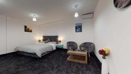 een slaapkamer met een bed en een tafel en stoelen bij WooW Apartments in Velika Gorica