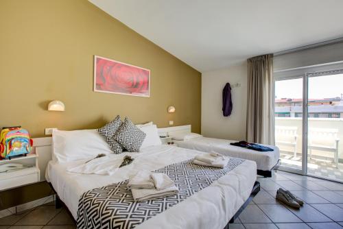 Habitación de hotel con 2 camas y ventana en Hotel Christian Ideale Per Famiglie, en Riccione
