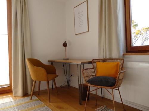 a room with a desk and two chairs and a table at Kraftquelle Waldhäuser in Neuschönau