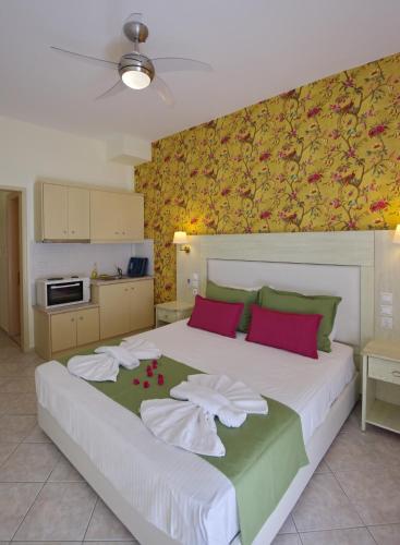a bedroom with a large white bed with red pillows at Pension Votsi in Votsi