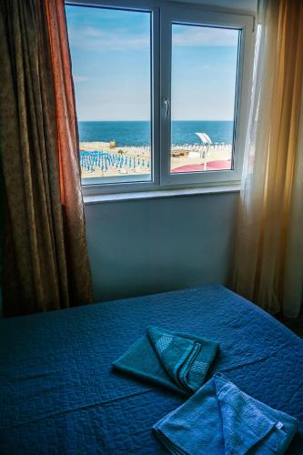 a bed with a window with a view of the ocean at Vila Gladiola in Eforie Nord