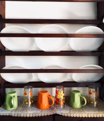 a shelf with plates and mugs on it at Electra in Líndos