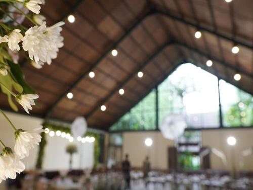 ein Zimmer mit Tischen und weißen Blumen darin in der Unterkunft Imah Seniman in Lembang