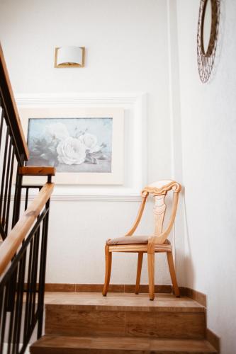 a wooden chair sitting on the stairs next to a painting at Hostal la Campana in Motril