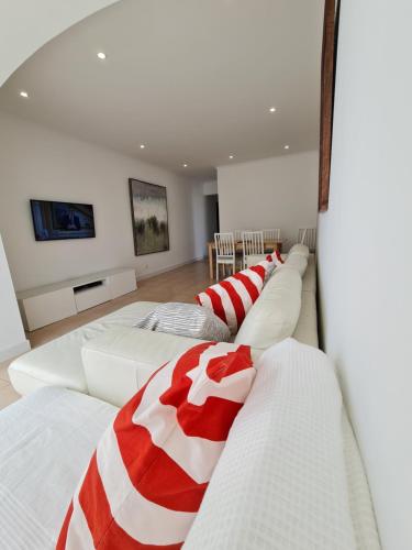 a room with four beds with red and white blankets at Casa da Praia da Costa in Costa da Caparica