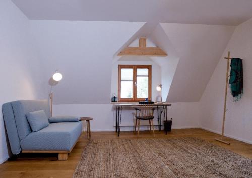 a living room with a blue chair and a table at Kraftquelle Waldhäuser in Neuschönau