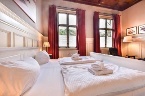 ヘリングスドルフにあるOstseepark Captain`s Haus 1 4の赤いカーテンが備わるドミトリールームのベッド2台分です。