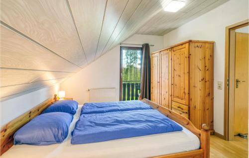 um quarto com uma cama com lençóis azuis e uma janela em Ferienhaus 4 In Kirchheim em Kirchheim