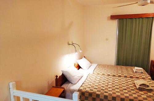 a bedroom with a bed with a checkered blanket at Sea N Lake View Hotel Apartments in Larnaka