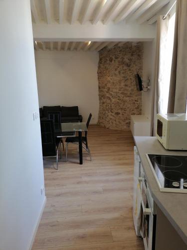 Il comprend une cuisine et un salon avec une table. dans l'établissement Au Thiernois, à Thiers