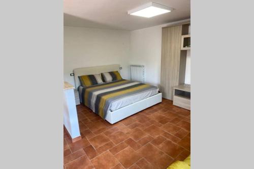 1 dormitorio con 1 cama y suelo de baldosa en Alloggio a via Impero en Lenola