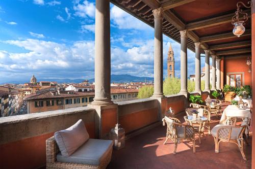 a balcony with tables and chairs and a view of a city at Hotel Palazzo Guadagni in Florence