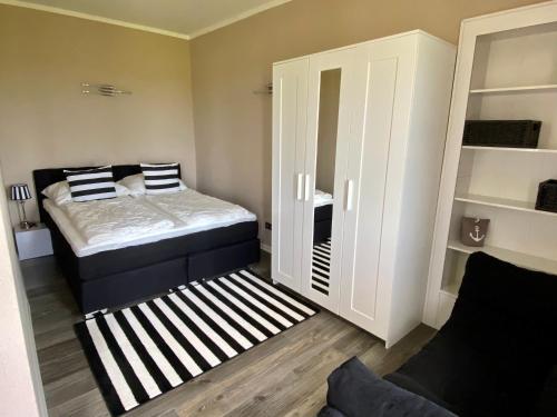 ein kleines Schlafzimmer mit einem Bett und einem Schrank in der Unterkunft Ferienwohnung PuraVida Ostsee 5A in Kühlungsborn