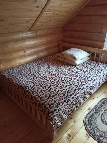 a bed in a room with a wooden ceiling at Біля річки in Izki