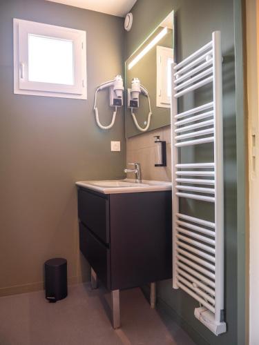 une salle de bain avec un lavabo et un miroir dans l'établissement Logis hôtels Le Saint Pierre, à Moncoutant