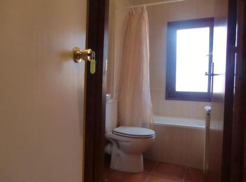 a bathroom with a toilet and a window at Casa Rural Jose Trullenque in Morella