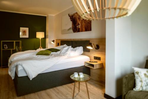 a bedroom with a large bed and a table at Berg und Tal Hotel & Apartments in Braunlage