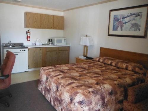 a hotel room with a bed and a kitchen at Tumbler Ridge Inn in Tumbler Ridge