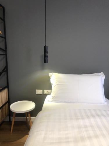 a bed with a white pillow and a table at Grand Hotel Pogradec in Pogradec