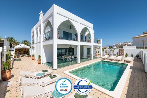 a villa with a swimming pool and a house at Riad Matias Galé - Luxury Villa with private pool, AC, free wifi, 5 min from the beach in Guia