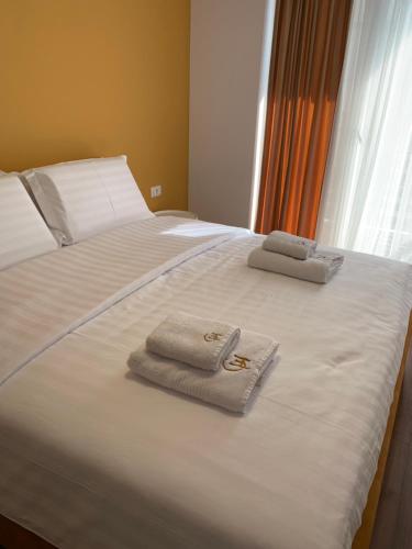 a bed with two towels sitting on top of it at Grand Hotel Pogradec in Pogradec