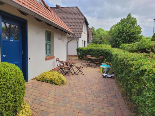 a patio with chairs and a table and a blue door at Kornmühle Doppelzimmer Mühlenstein in Mellenthin