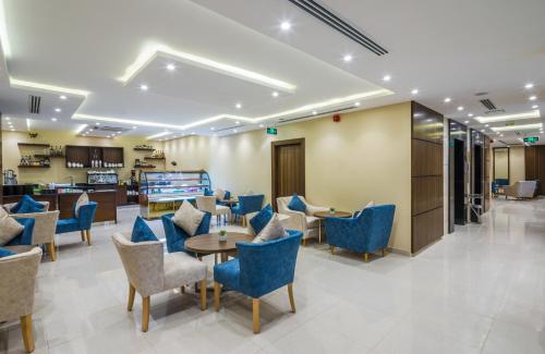 a waiting room with blue chairs and tables at Myrtle AlSahafa Hotel فندق ميرتل الصحافه in Riyadh