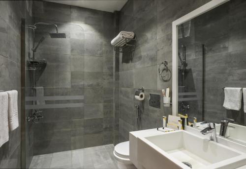 een badkamer met een wastafel, een toilet en een douche bij Myrtle Hotel - Al Sahafa in Riyad