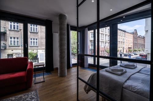 Habitación con cama, sofá y ventanas. en Aparthotel Inspire Miodova Residence, en Cracovia