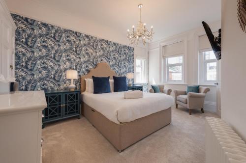 a bedroom with a bed with a blue and white wallpaper at Stattons Boutique Hotel & Restaurant in Portsmouth