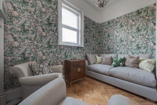 a living room with a couch and floral wallpaper at Stattons Boutique Hotel & Restaurant in Portsmouth