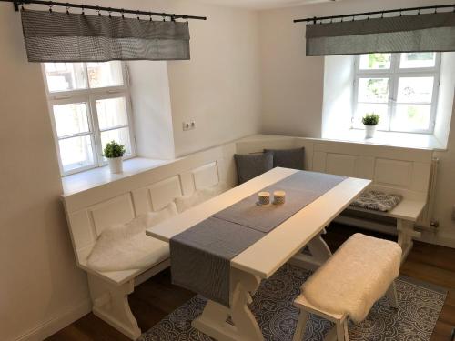 a dining room with a table and two windows at Ferienhaus im Fichtelgebirge in Nagel