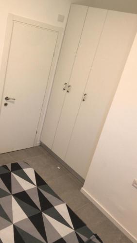 a room with white doors and a black and white floor at Isramax low-cost apartment near the sea. in Bat Yam
