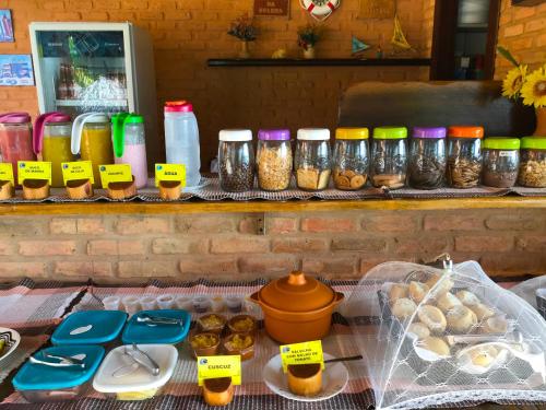 a table with jars of food and other food items at Hotel Pousada Beleza das Ondas in Cumbuco
